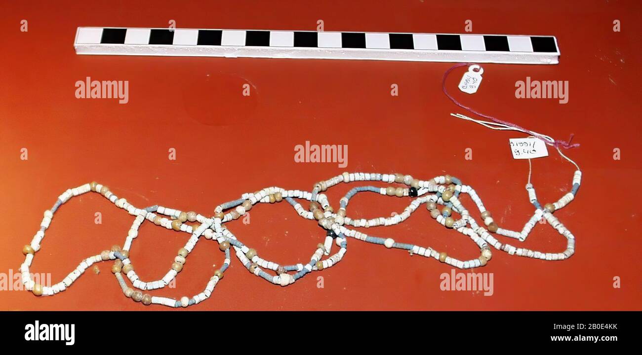 A long necklace consisting of a large number of small beads, most made of faience. Most faience beads are white, blue and light blue in color, some are orange and light purple in color., The beads are short cylindrical Stock Photo