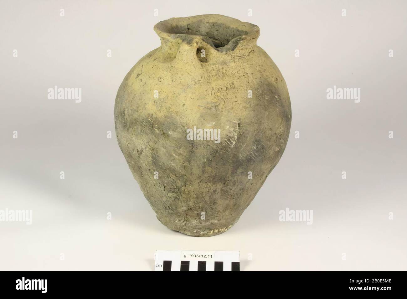 Pot of coarse so-called Frisian earthenware with two ears and serrated edge. Found in pit I. With cracks in the wall, a crack in the edge, a lacuna in the edge and a damaged surface., Pot, earthenware, h: 27 cm, diam: 22.5 cm, roman, Netherlands, North Holland, Schagen, Schagen Stock Photo