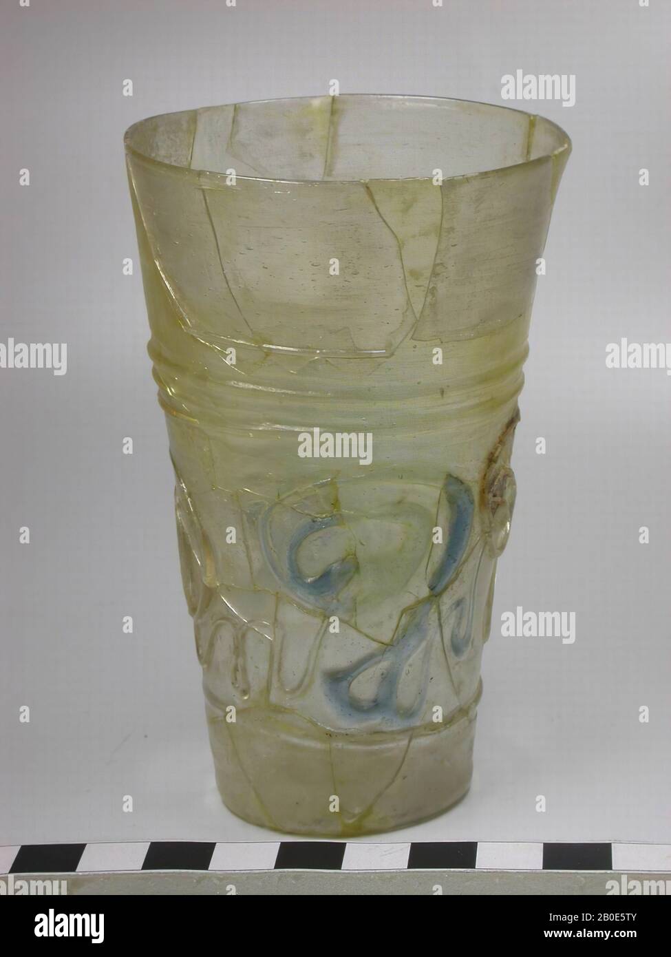 Cup of decolored glass with a decoration of untidy glass threads, alternately in figures in colorless and blue glass. Broken and partly reconstructed., Crockery, glass, H 11 cm, Iran Stock Photo