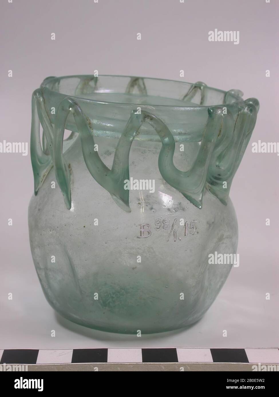 Light green glass jar with spherical belly and wide mouth. At the neck a zigzag decoration of glass wire. The belly has snaps, dishes, glass, blown, H 8 cm, D 7.5 cm, Israel, Palestine Stock Photo