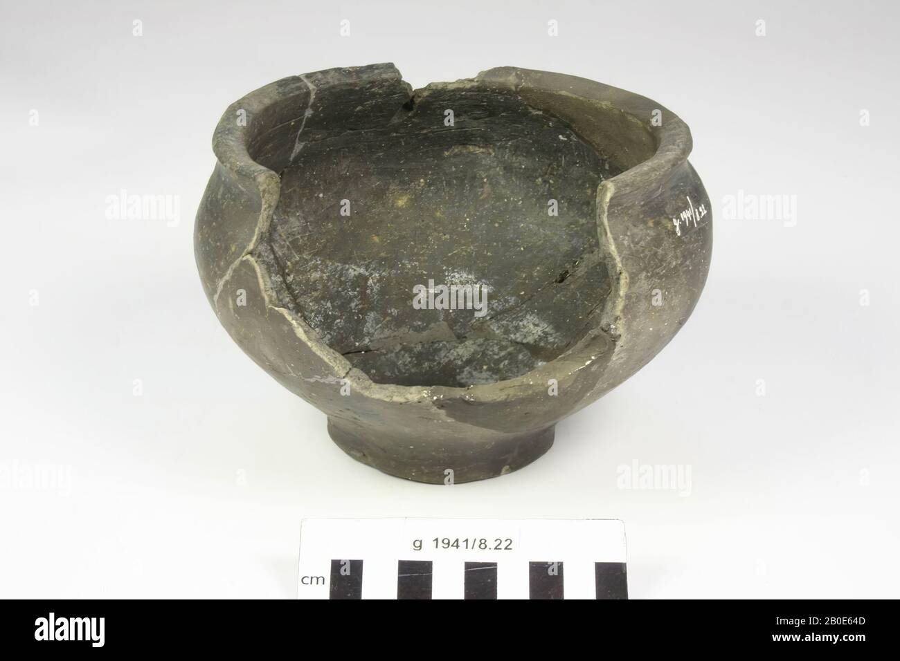 A small piece of crockery, earthenware, indigenous produce, covered by a black-blue shiny layer. Graceful shape, edge slightly profiled. No decoration. From well B. The whole consists of old glues and additions, part of the wall and rim is missing, gap in the edge, pot, pottery, h: 12.3 cm, diam: 17.5 cm, roman, Netherlands, North Holland, Uitgeest, Dorregeest Stock Photo