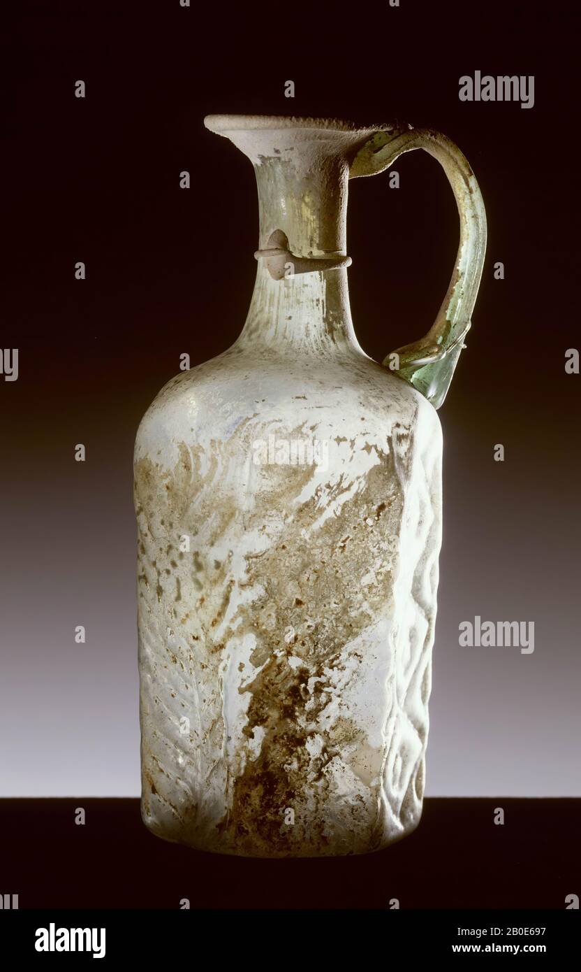Pilgrim bottle. Six-sided jug of pale green glass with diamond-shaped ornaments, narrow neck with wide mouth and an ear of slightly dark green glass thread. Two of the sides are decorated with a human face in a spring-like environment., Crockery, bottle, glass, mold-blown, H. 20 cm, Byzantine Period 600-700 ad, Lebanon Stock Photo