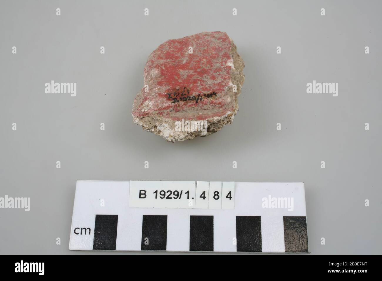 A piece of wall plaster, painted with red paint., Varia, lime mortar, L 6.5 cm, W 4.9 cm, Palestine Stock Photo