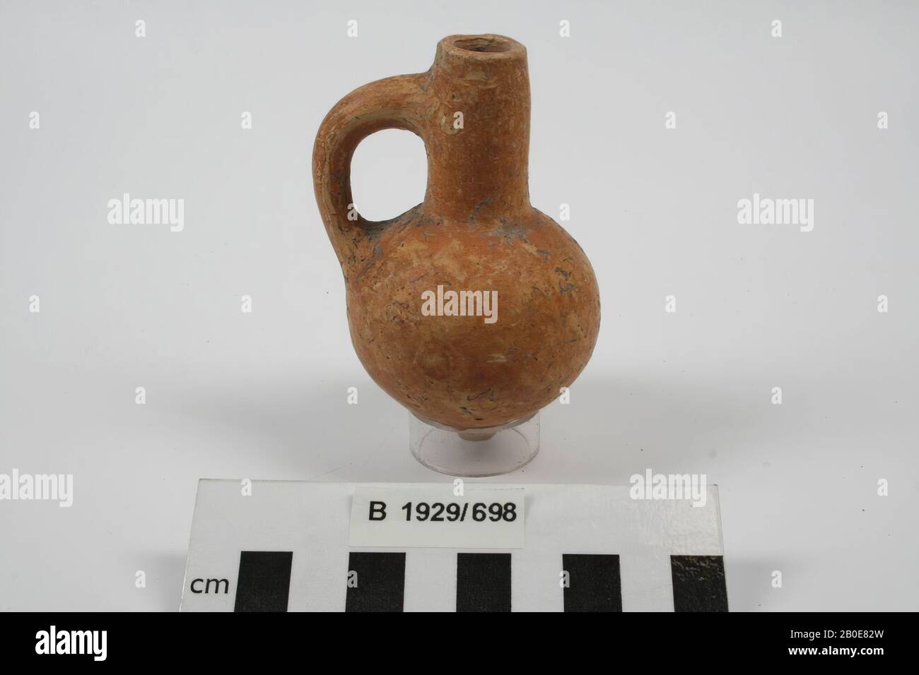 An earthenware jug with long neck, one earpiece and a ball body. The object is red slippled., Crockery, pottery, H 9 cm, D belly 5.6 cm, Iron Age II 925-539 BC, Palestine Stock Photo