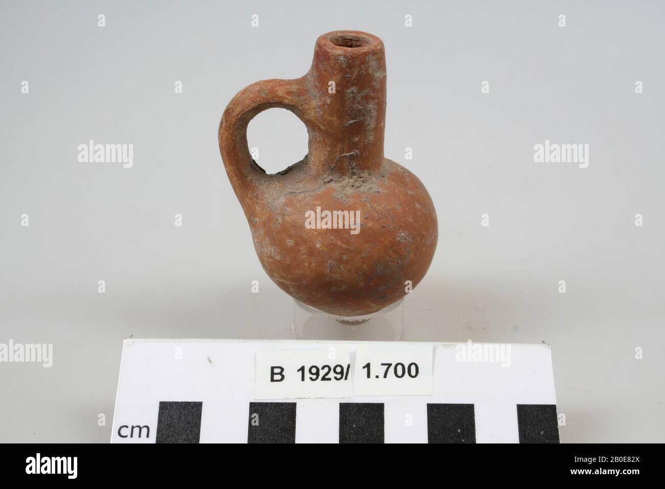 an earthenware jug with straight neck, one earpiece and ball body. The object is red slotted, crockery, earthenware, H 8 cm, D 4.9 cm, W 5.3 cm, Iron Age II 925-539 BC, Palestine Stock Photo