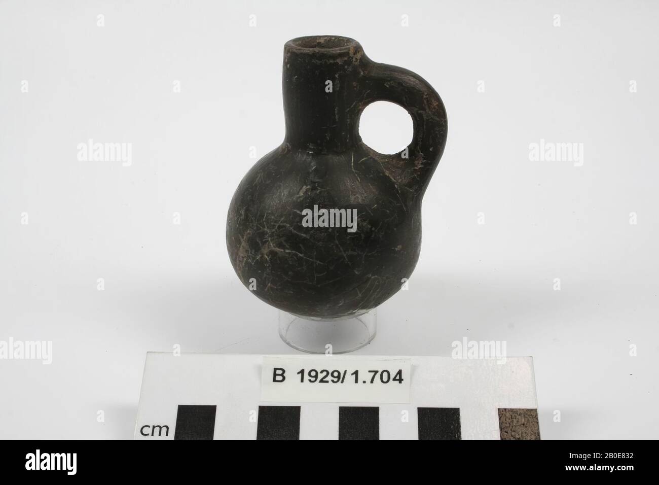 A small earthenware jug with a straight neck, one earpiece and a rounded body. The object is black slippled and polished., Crockery, pottery, H 8.2 cm, D belly 5.7 cm, Iron Age II 925-539 BC, Palestine Stock Photo