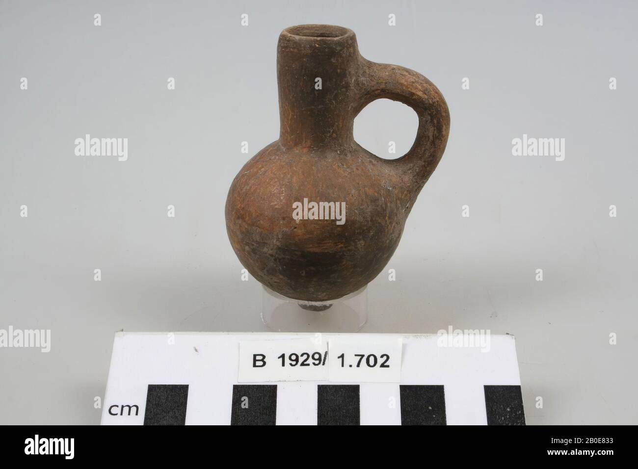 A small earthenware jug with a straight neck, one earpiece and a bulbous body. The object is brown-red slotted, crockery, earthenware, H 7.9 cm, D 4.7 cm, Iron Age II 925-539 BC, Palestine Stock Photo