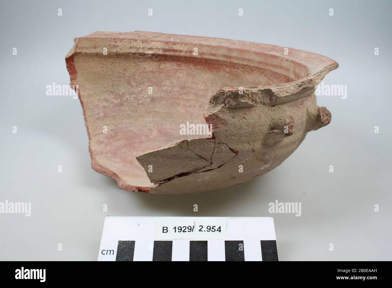 One half of a cooking pot with a strongly outward edge. The handles are