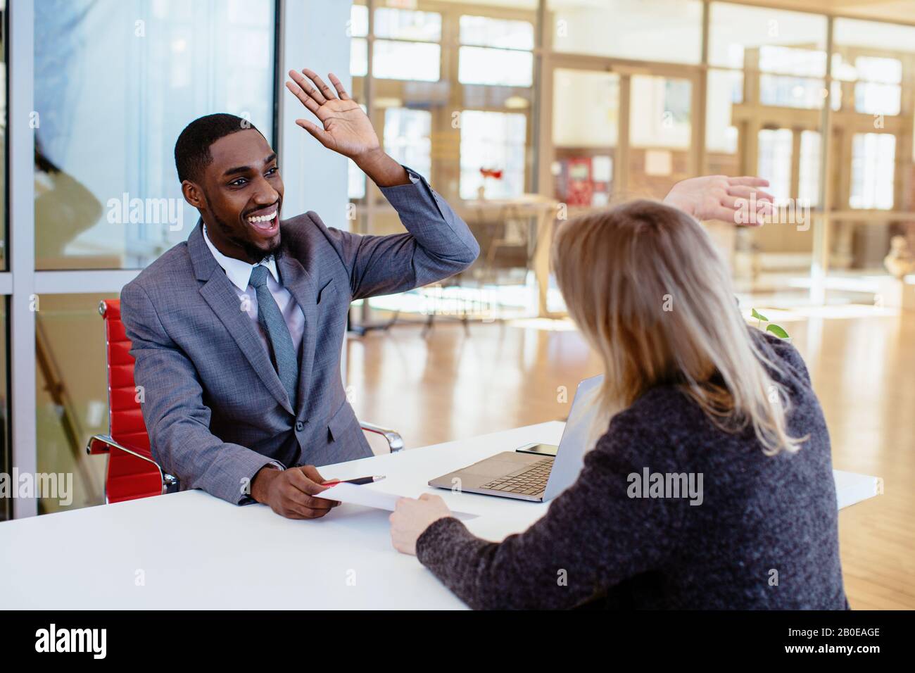 Portrait of a happy smiling young man in business suit celebrating ...