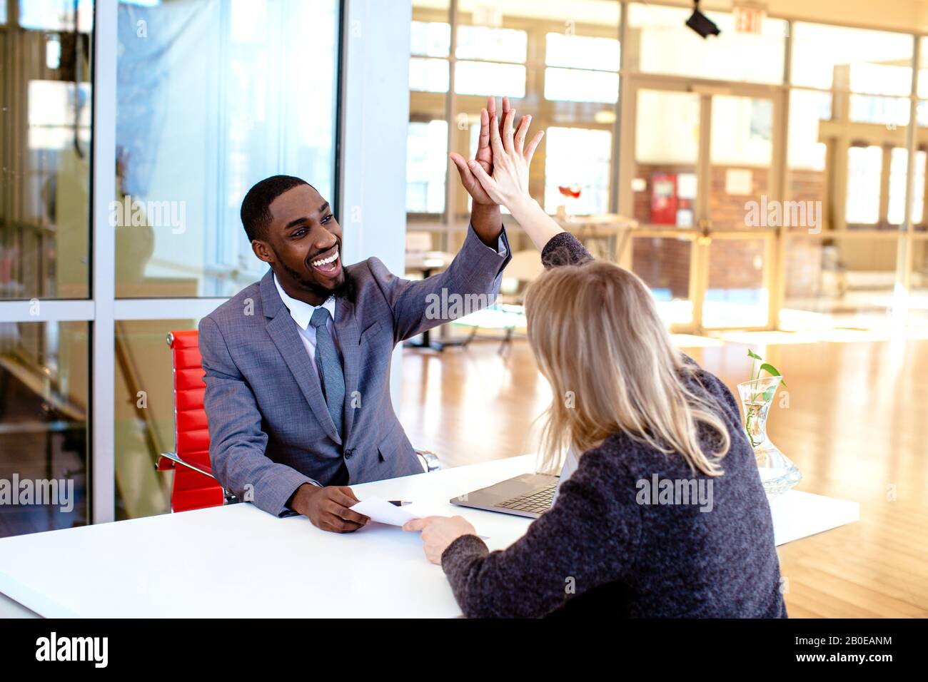 Portrait of a happy smiling young man in business suit celebrating ...