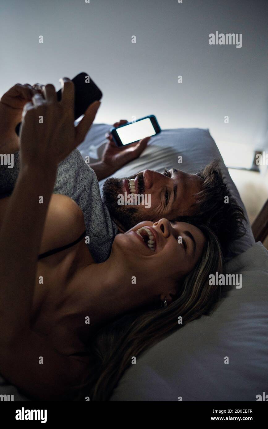 Cheerful young couple using smartphones Stock Photo