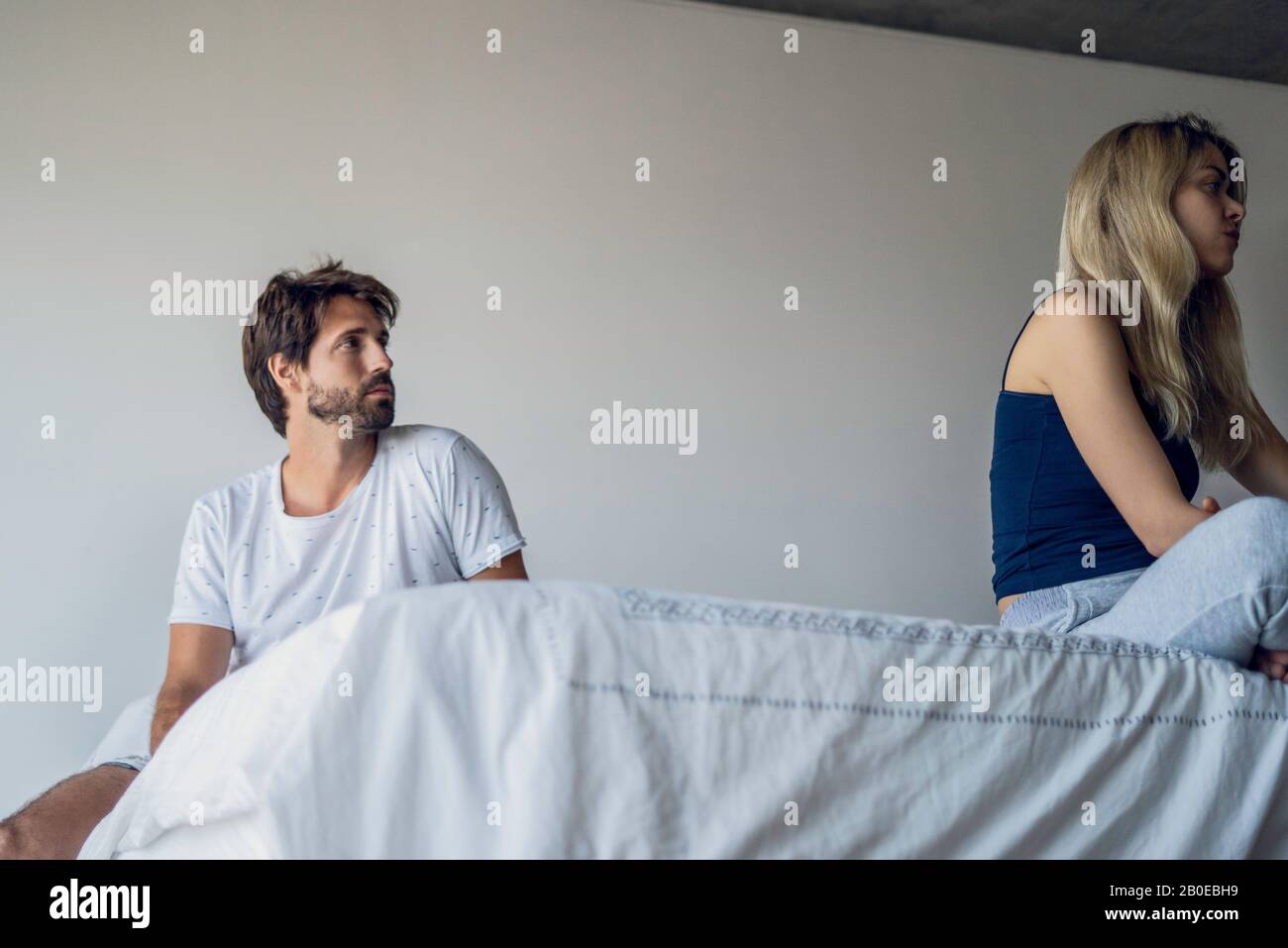 Upset couple sitting on bed Stock Photo