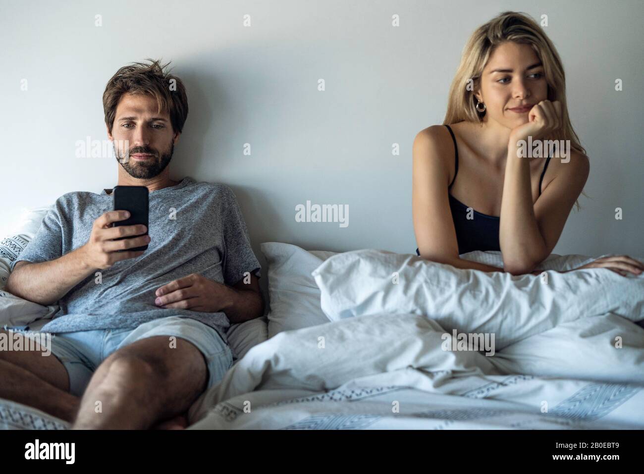 Young couple sitting on bed Stock Photo