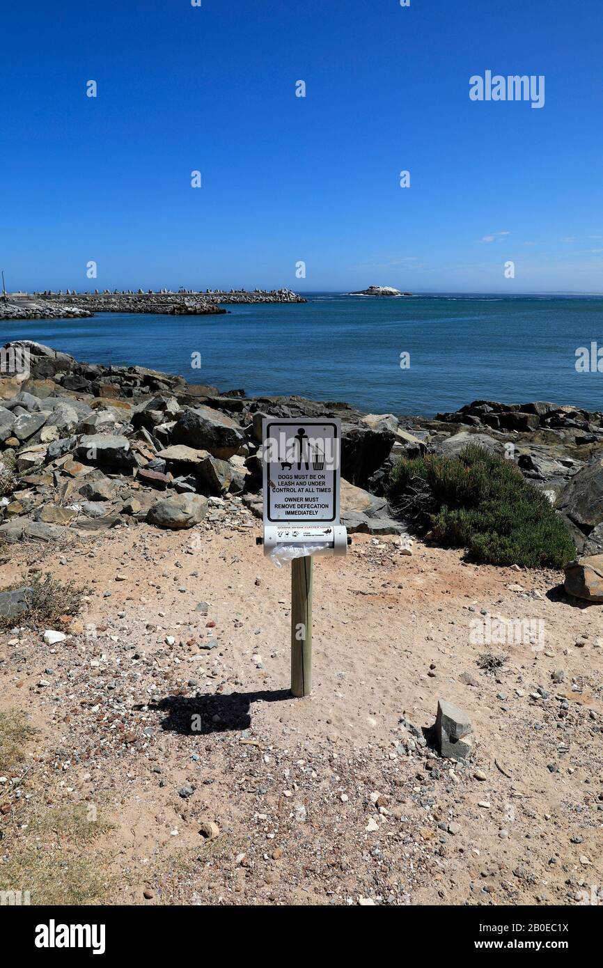 Dog poo bag disposal unit and sign in the small harbour town of Yzerfontein in the Western Cape Province on the west coast of South Africa. Stock Photo