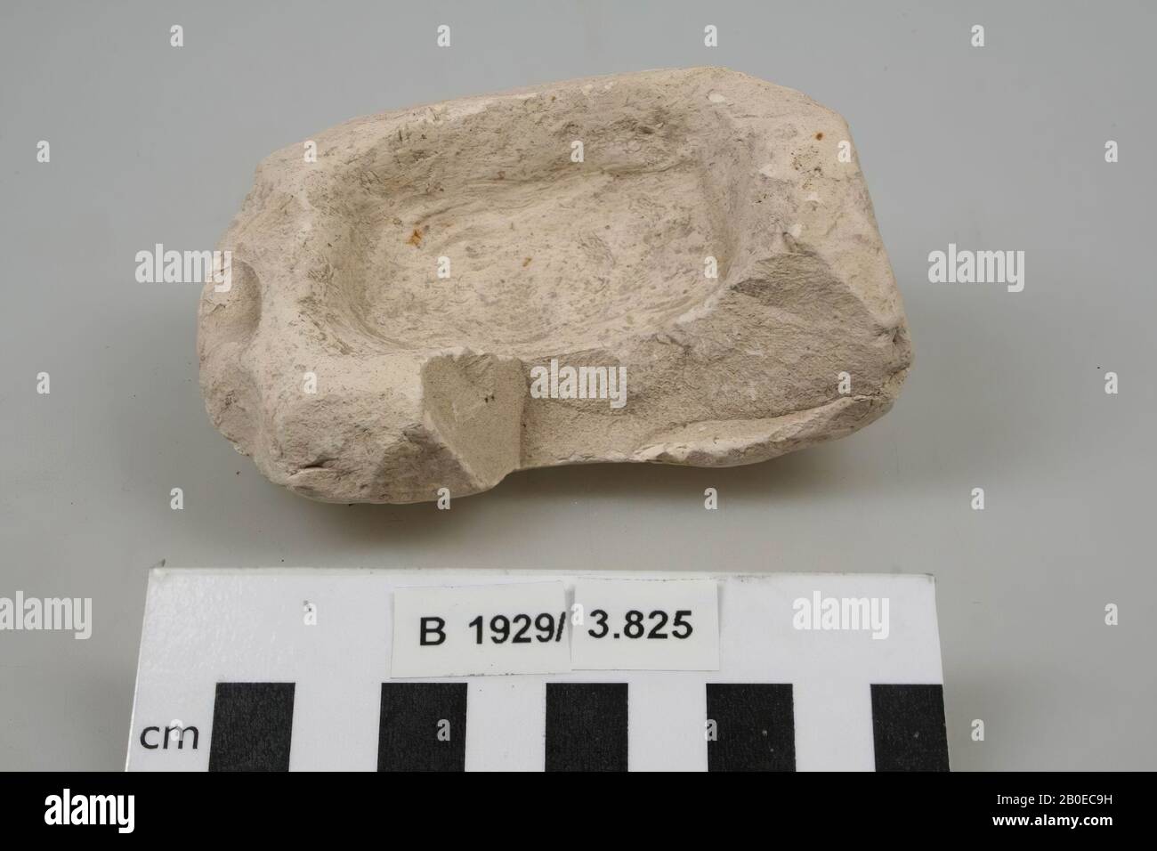 A fragment of a rectangular bowl or mortar, roughly made of limestone. Especially the outside shows irregularities, grindstone, crockery, stone, limestone, L 10.3 cm, W 7.5 cm, H 4.7 cm, Palestine Stock Photo