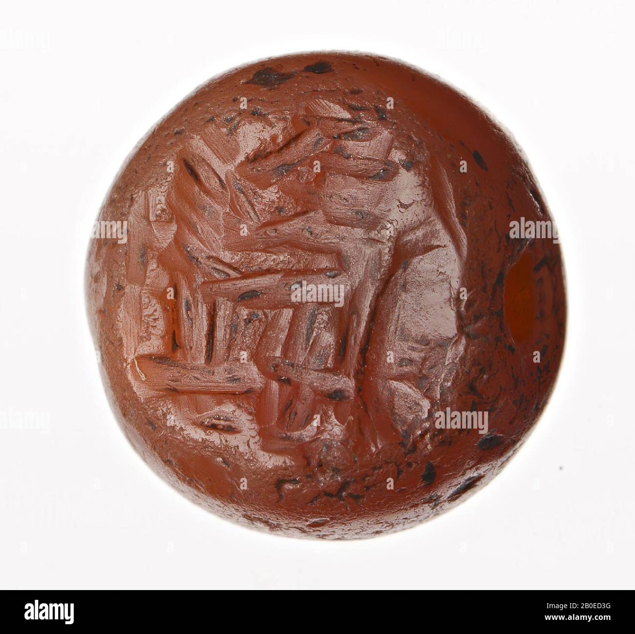 A dome-shaped stamp with an image of a standing priest (?) In front of a fire altar., Seal, stone, carnelian, H 0.9 cm, D1.2 cm, Iran Stock Photo