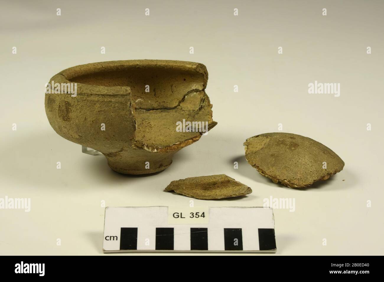 Bowl of rough-walled earthenware. With old bonds that have partly released and some small additions. In addition, 2 separate fragments from the edge Stock Photo