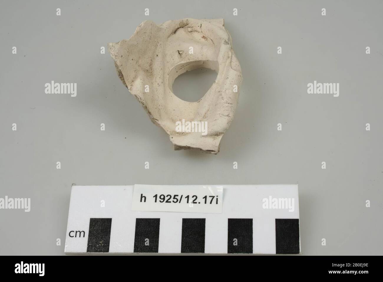 Fragment of terracotta theater mask. Possibly a male face. Left right ear with hole. Ear has probably stood far from the face. Also the beginning of thick skin folds are visible.