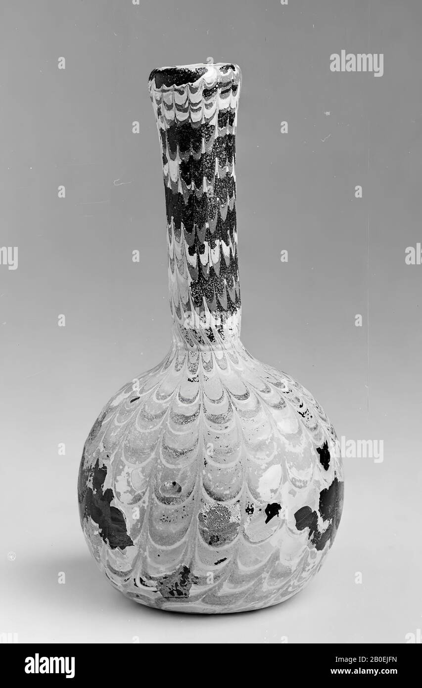 Bottle with bullet-shaped belly and long neck. Quite thick-walled but blown. The original color can not be determined with certainty due to iridescence. Whole surface is worked with lightly melted opaque glass threads., Bottle, glass, 15 cm, Italy Stock Photo