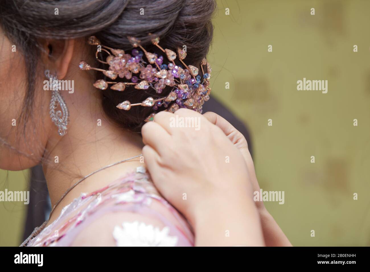 Groom wearing a necklace to the bride. mother of bride helping to dress up the necklace her beautiful daughter indoors . Bride wearing a necklace . He Stock Photo