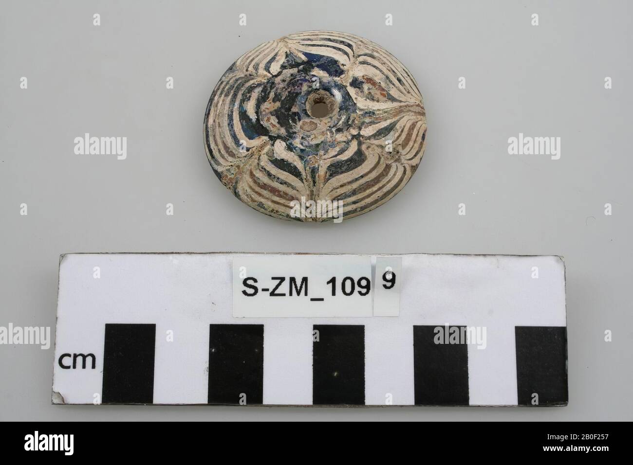 Disc shaped glass bead. With a perforation and decorations., Quadruple bead, glass, 0.9 x 4.6 cm, unknown, unknown, unknown, unknown Stock Photo