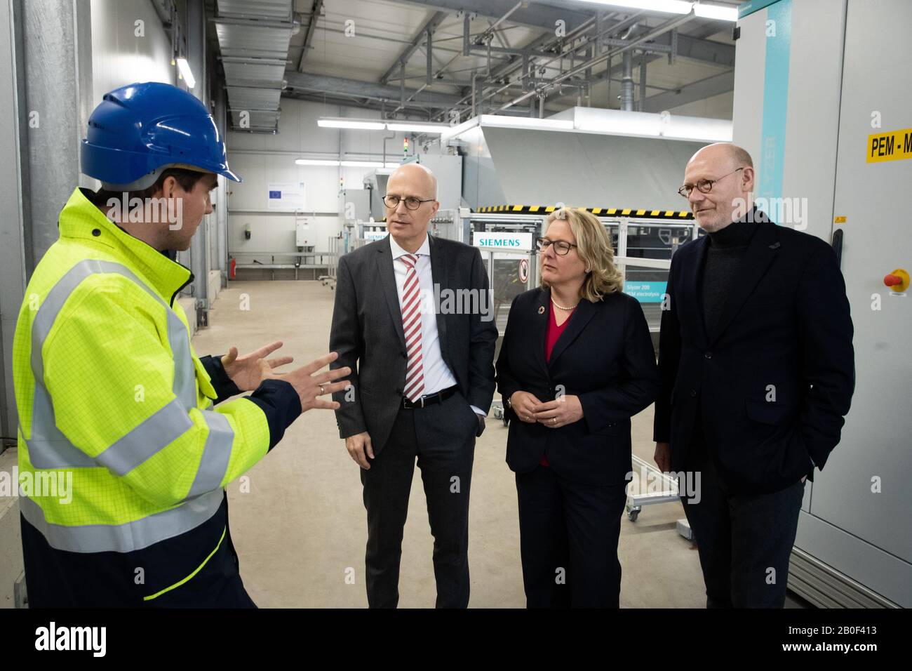 Hamburg, Germany. 20th Feb, 2020. Frederik Jahnke (l), Head of Process Engineering at H&R Ölwerke (Hansen&Rosenthal), explains Peter Tschentscher (SPD), First Mayor of Hamburg and top candidate for the state election, Svenja Schulze (SPD, 2nd from right), Federal Minister for the Environment, Nature Conservation and Nuclear Safety, and Michael Westhagemann (non-party, r), Senator for Economics, Transport and Innovation in Hamburg, how the hydrogen electrolysis plant works during a visit to H&R Ölwerke. Credit: Christian Charisius/dpa/Alamy Live News Stock Photo