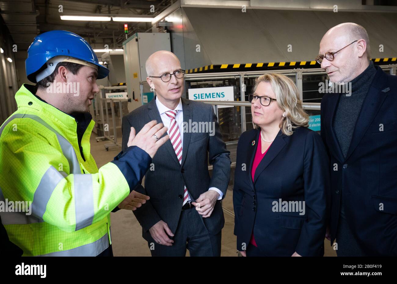 Hamburg, Germany. 20th Feb, 2020. Frederik Jahnke (l), Head of Process Engineering at H&R Ölwerke (Hansen&Rosenthal), explains Peter Tschentscher (SPD), First Mayor of Hamburg and top candidate for the state election, Svenja Schulze (SPD, 2nd from right), Federal Minister for the Environment, Nature Conservation and Nuclear Safety, and Michael Westhagemann (non-party, r), Senator for Economics, Transport and Innovation in Hamburg, how the hydrogen electrolysis plant works during a visit to H&R Ölwerke. Credit: Christian Charisius/dpa/Alamy Live News Stock Photo