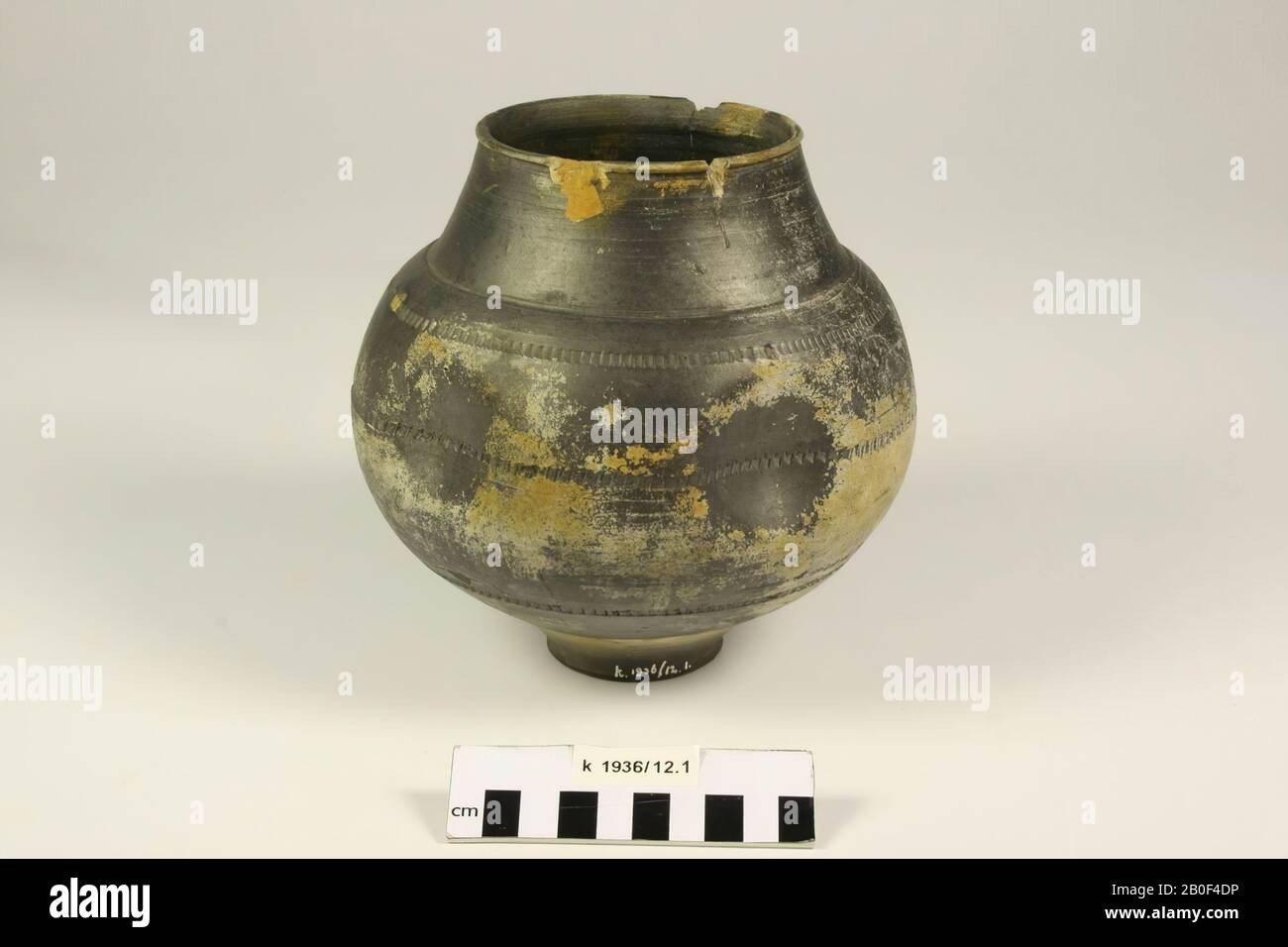 Large cup with folded wall of Roman gray painted earthenware. Old bondings and additions, chips from the edge, rust stains on the inside, yellow discolouration on the outside., Beaker, dented cup, earthenware, h: 16.7 cm, diam: 16.3 cm, roman, Netherlands, North Brabant , Oss, Megen, Maas Stock Photo