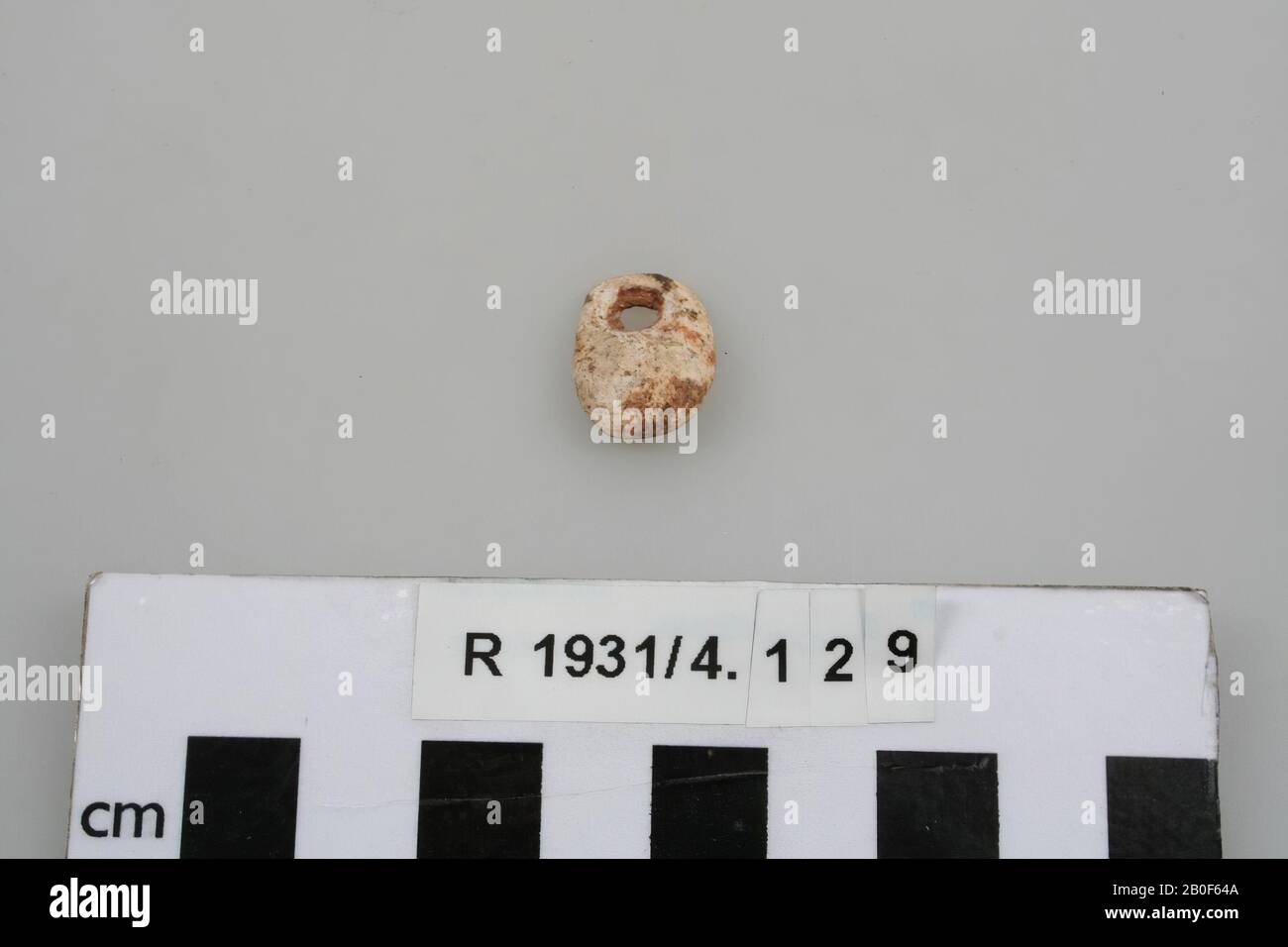 Flat oval leg amulet, pierced, amulet, organic, bone, 1,6 x 1,3 x 0,5 cm, France, unknown, unknown, unknown Stock Photo