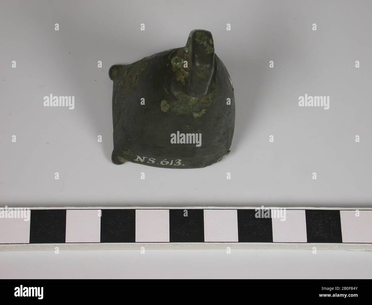 Pyramid shaped bronze bell with 6-sided handle. At the bottom 4 feet, of which 2 are missing. Also a part of one side has been lost., Bell, metal, bronze, height: 6 cm, roman 1-300, Netherlands, Gelderland, Nijmegen, Nijmegen, Waal Stock Photo