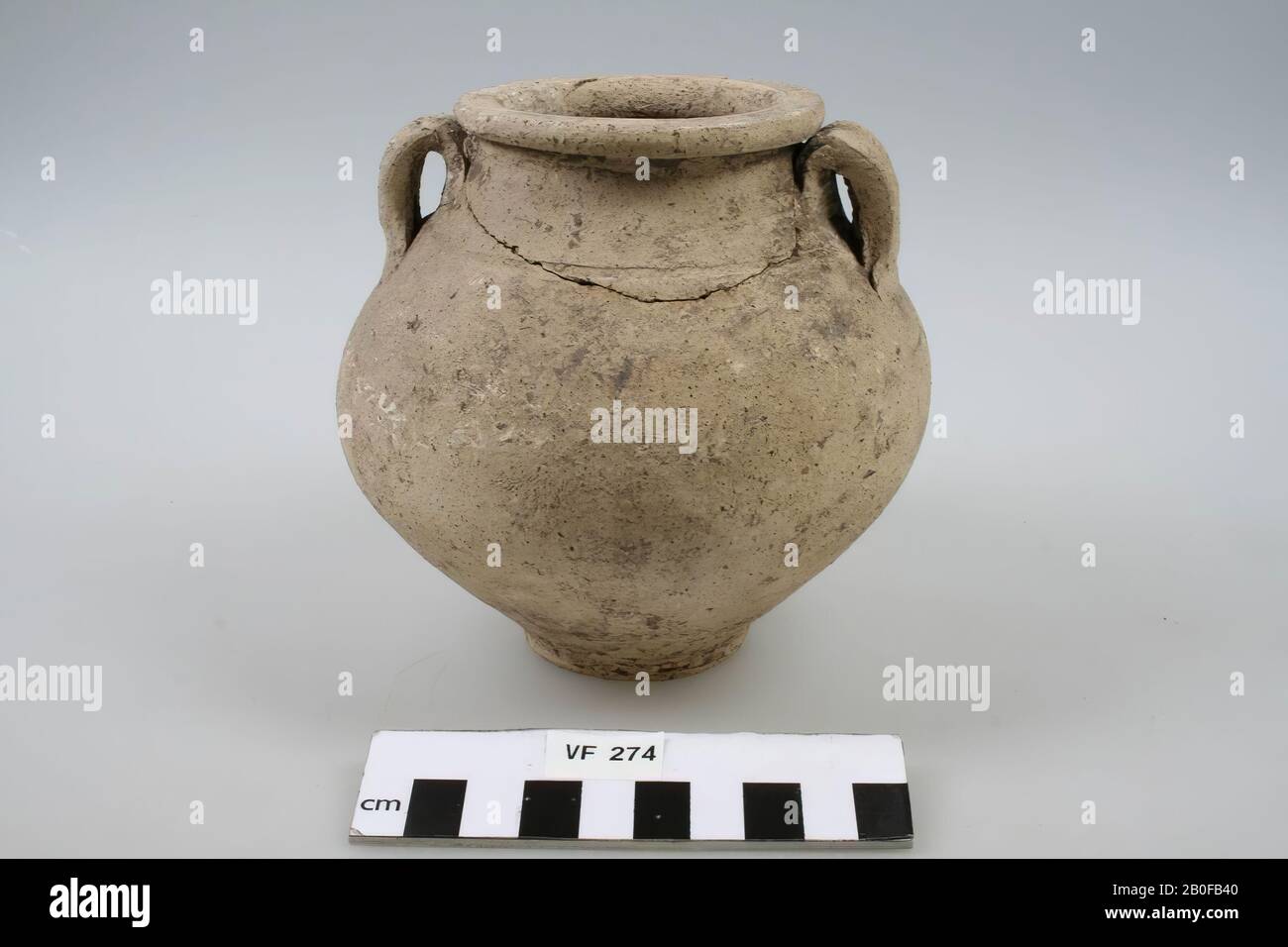 Roman pot, so-called honey pot, pale yellow earthenware. At the end of the 1st century approximately. Hole in the wall, old gluing and filling, chips from the edge, honey jar, pottery, h: 12 cm, diam: 12,7 cm, roman About the end of the 1st century AD, the Netherlands, Utrecht, Bunnik, Vechten Stock Photo