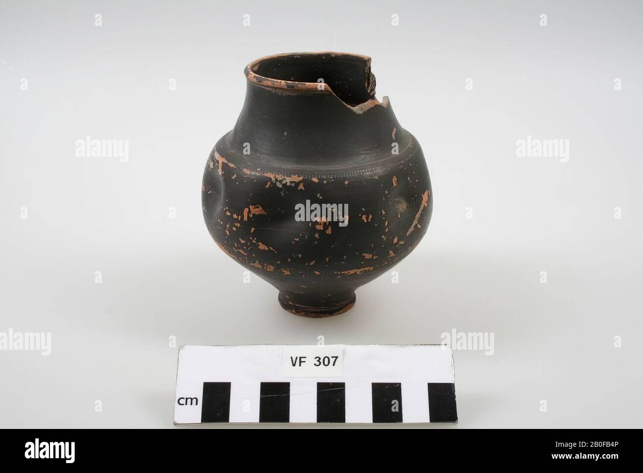 Black lacquered cup of convex shape with high edge, narrow flat foot and squeezed wall. Part of the rim and neck is missing, the paint layer is partially peeled off., Cup, dented cup, earthenware, h: 10.5 cm, diam: 9.2 cm, roman, Netherlands, Utrecht, Bunnik, Fighting Stock Photo
