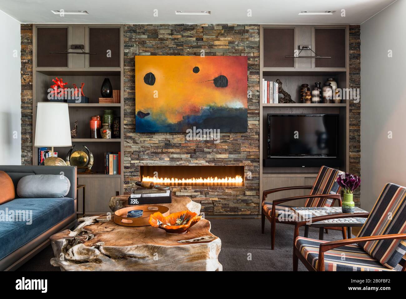 Slate lined wall with coffee table made from a solid piece of wood and antique lamps Stock Photo
