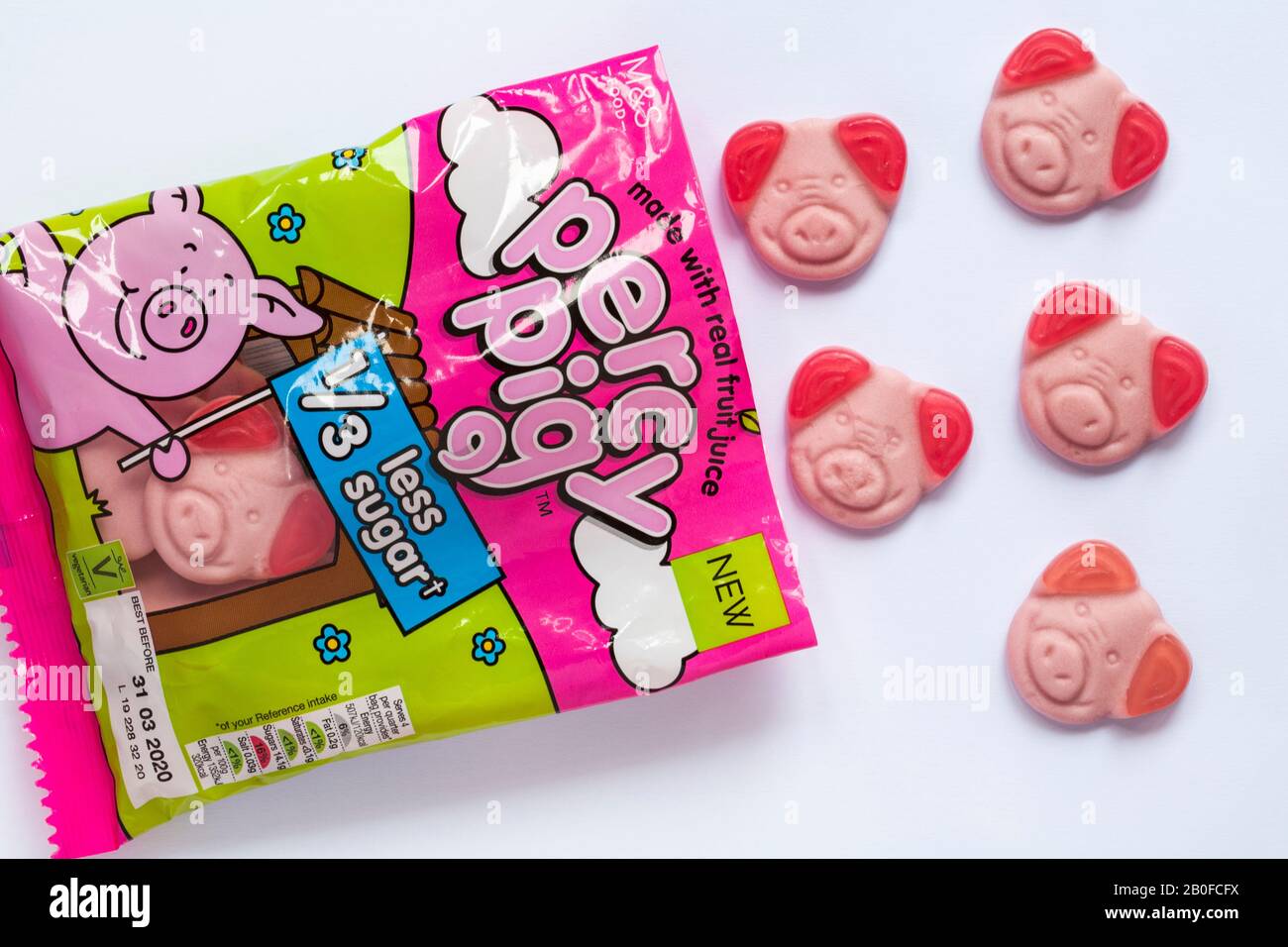 Bag of M&S Percy Pig sweets with 1/3 third less sugar soft fruit flavour gums made with real fruit juice open to show contents set on white background Stock Photo