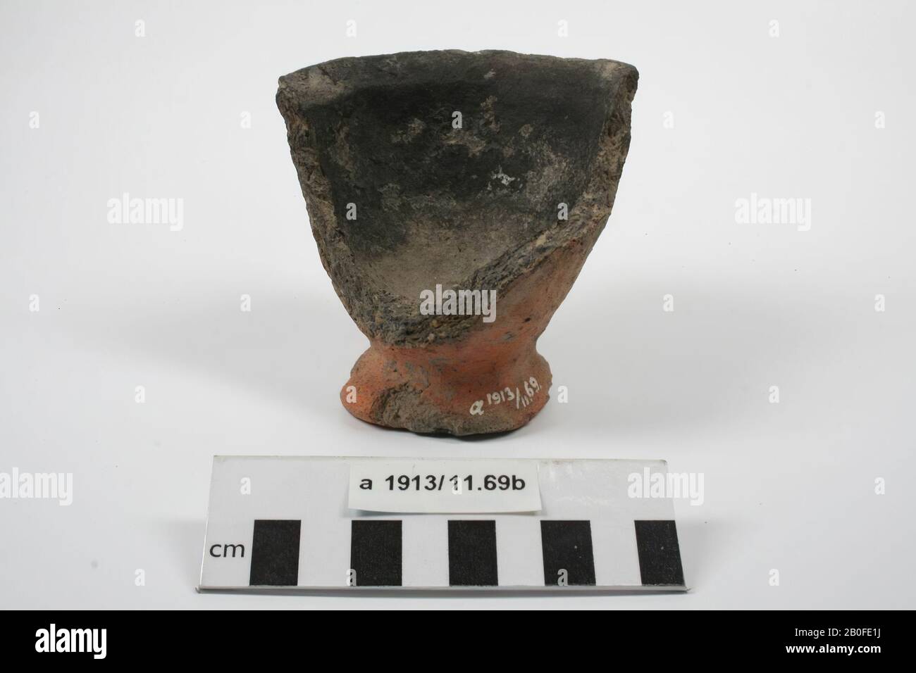 Fragment of a grease pot of hand-formed earthenware. Half of the rim and wall is missing, grease pot, fragment, earthenware (hand molded), h: 8.4 cm, diam: 8.2 cm, vme 1300-1400, Netherlands, Friesland, Dongeradeel, Dokkum, Berg Sion Stock Photo