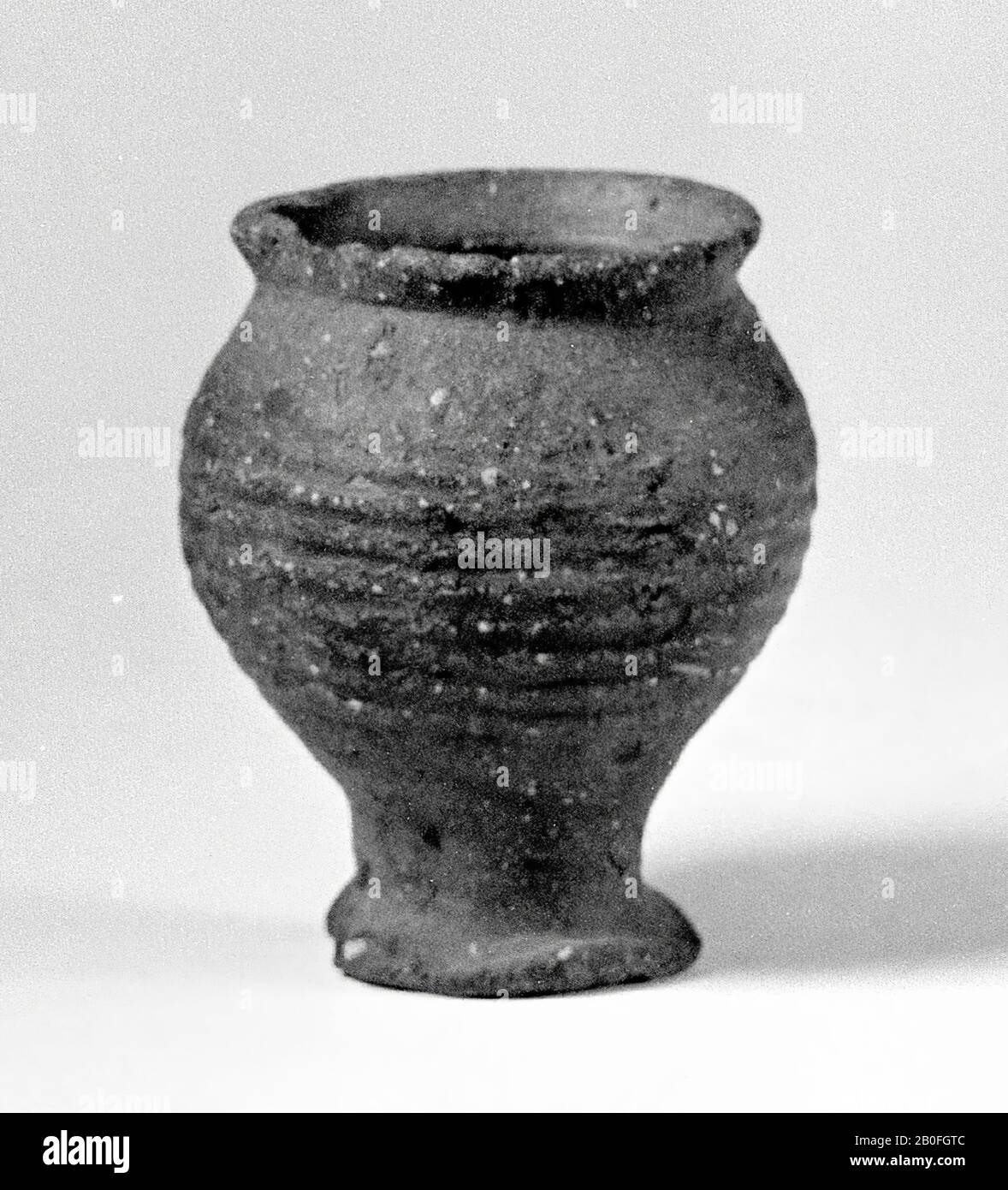 Sphere jar on barely waved high foot, with squeezed spout of hard-baked, dark brown earthenware with white speckles, twelfth or thirteenth century., cup, earthenware, proto-stoneware, h: 9 cm, diam: 7, 7 cm, lmeb 1200-1400 AD, The Netherlands, Gelderland, unknown, unknown Stock Photo