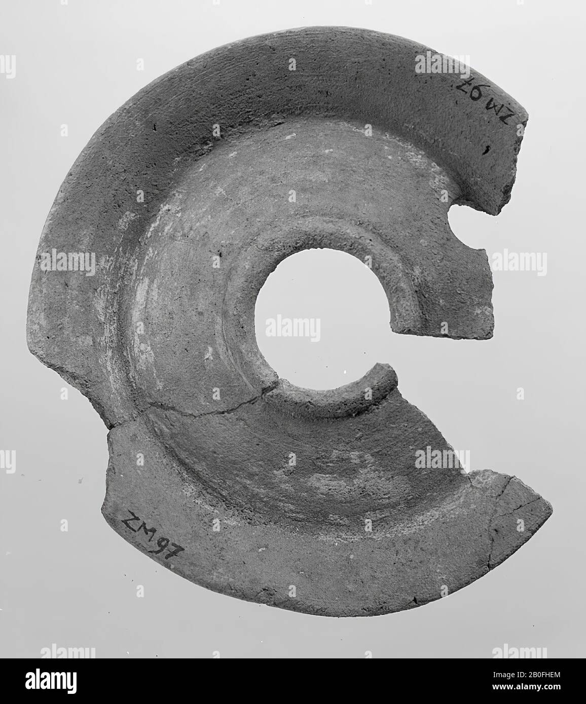 A fragment of the upper side of an oil lamp of light earth, with a large filling hole in the middle, oil lamp, earthenware, terracotta, 1.7 x 10.1 x 10.1 cm, unknown Stock Photo