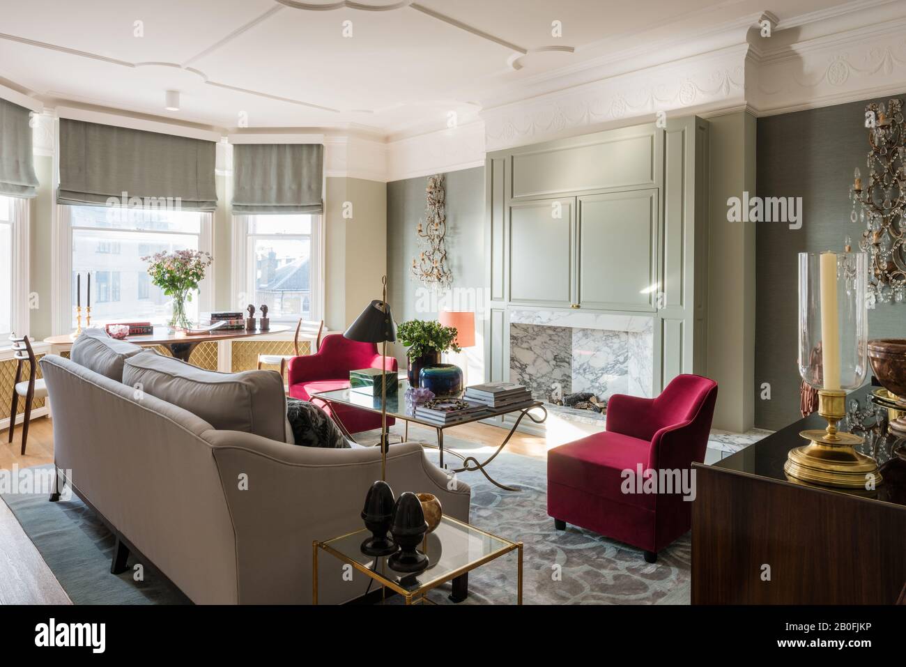 Blend of vintage and contemporary pieces in Victorian redesign with bespoke armchairs in red velvet Stock Photo