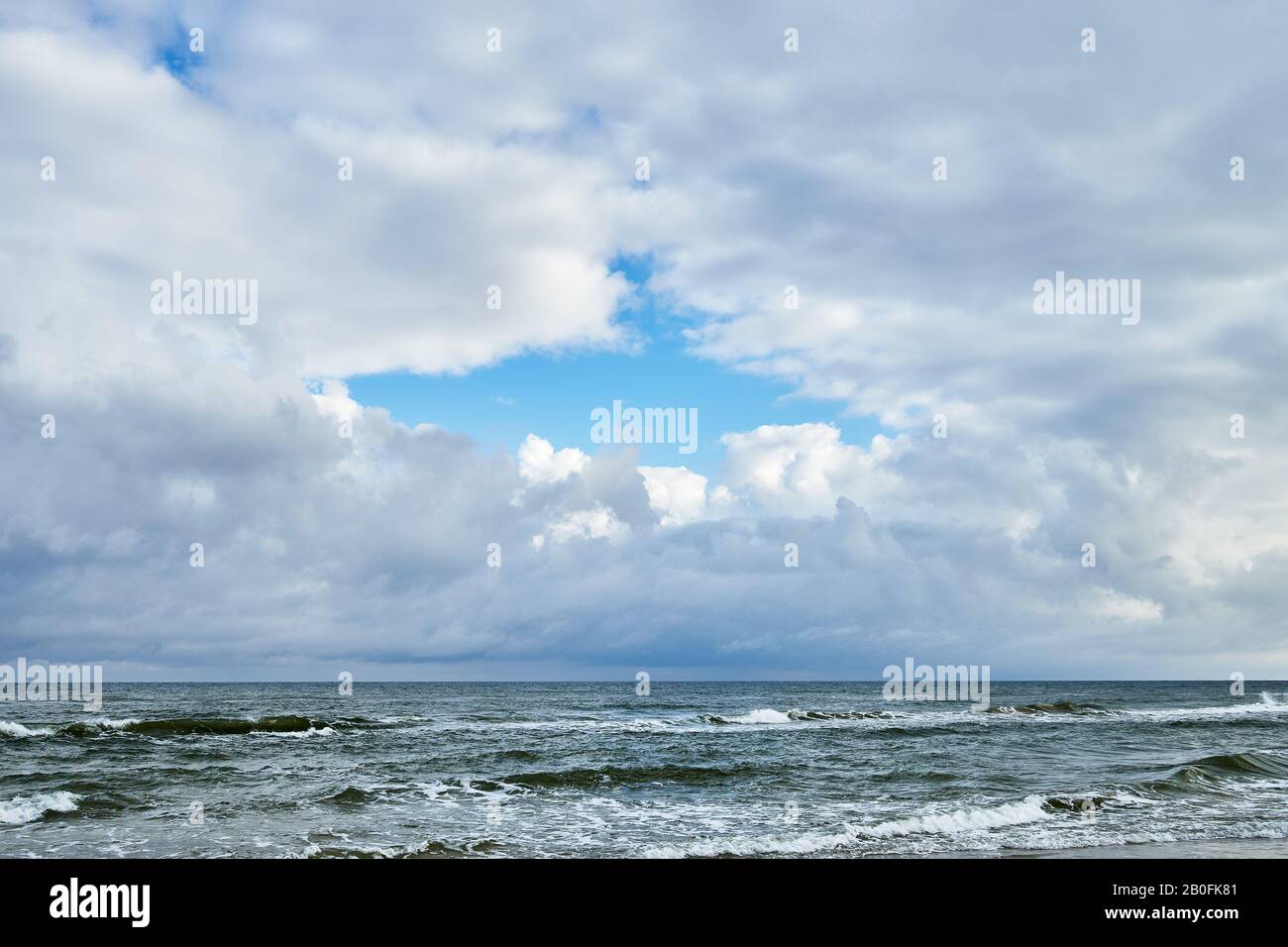 Dramatic cloudy sky over sea horizon after rain. Stock Photo