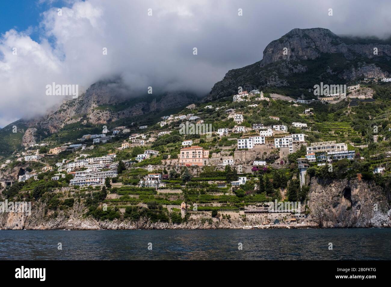 View of the Amalfi Coast, mountains and clouds seen from the sea along the Italian coastline. Stock Photo