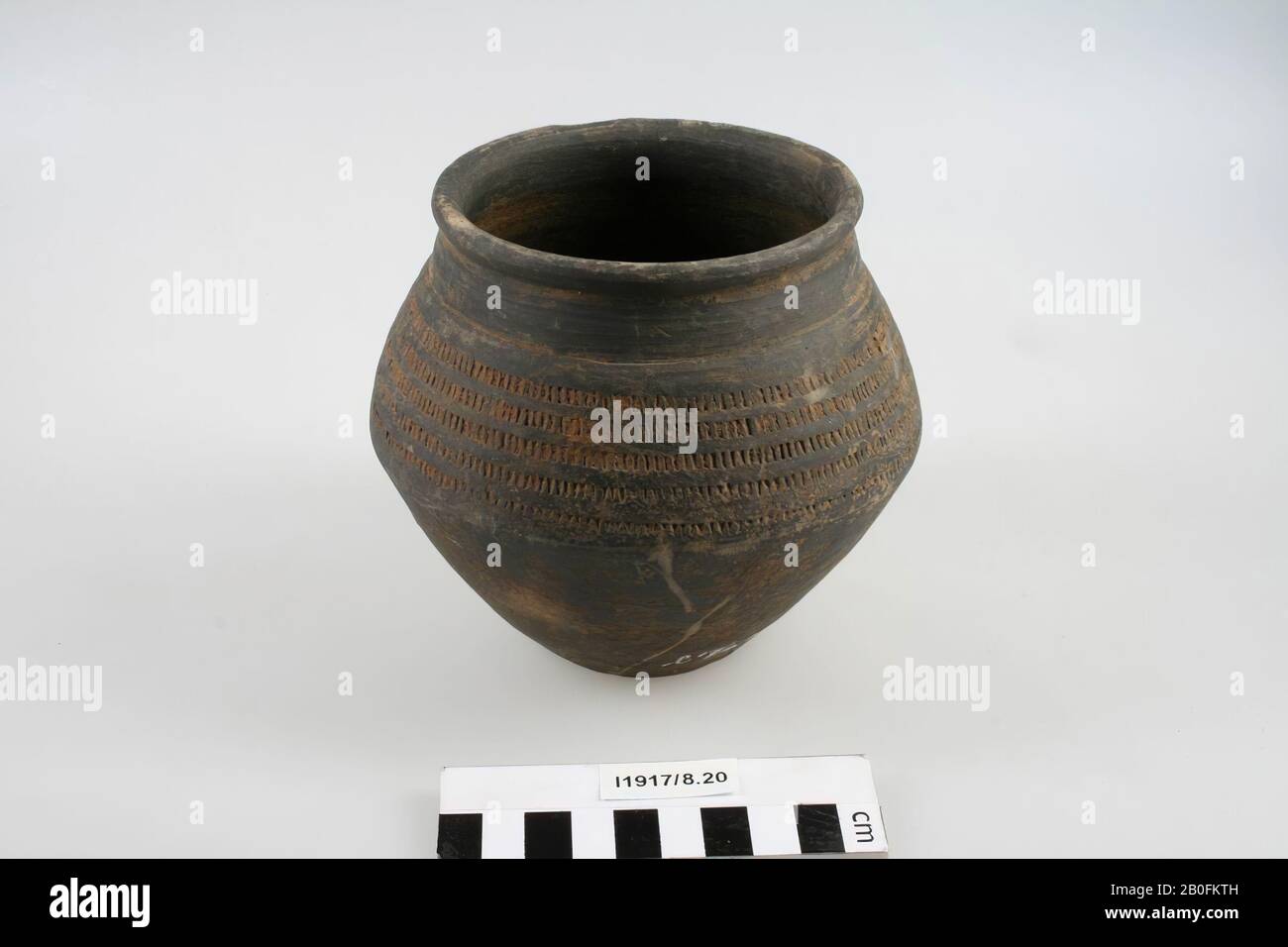 Folding pot with pressed vertical lines in horizontal bands. Chip from edge, small crack on the inside of the edge, slight damage to the surface., Bending pot, earthenware (Frankish), h: 12.8 cm, diam: 13.7 cm, vmeb 600-650, Netherlands, Limburg , Roermond, Swalmen Stock Photo