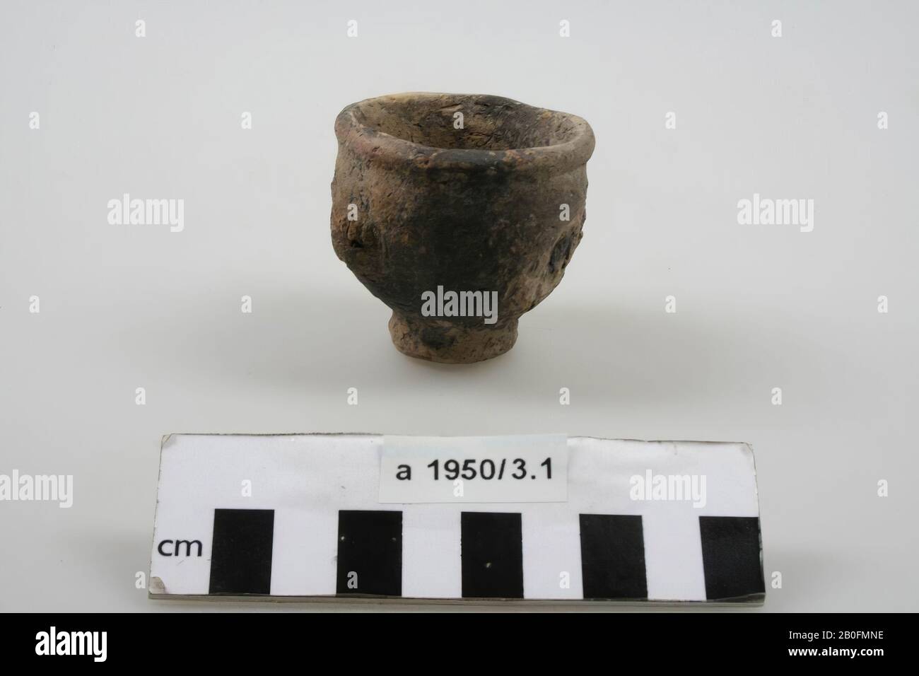 Small cream jar of light colored, hand shaped earthenware (terpaware), standing on a separate foot. The belly decorated with three lumps. Surface damage at the nodules, cream jar, earthenware, terpaware, h: 5.2 cm, diam: 5.4 cm, roman, Netherlands, Friesland, unknown, unknown Stock Photo