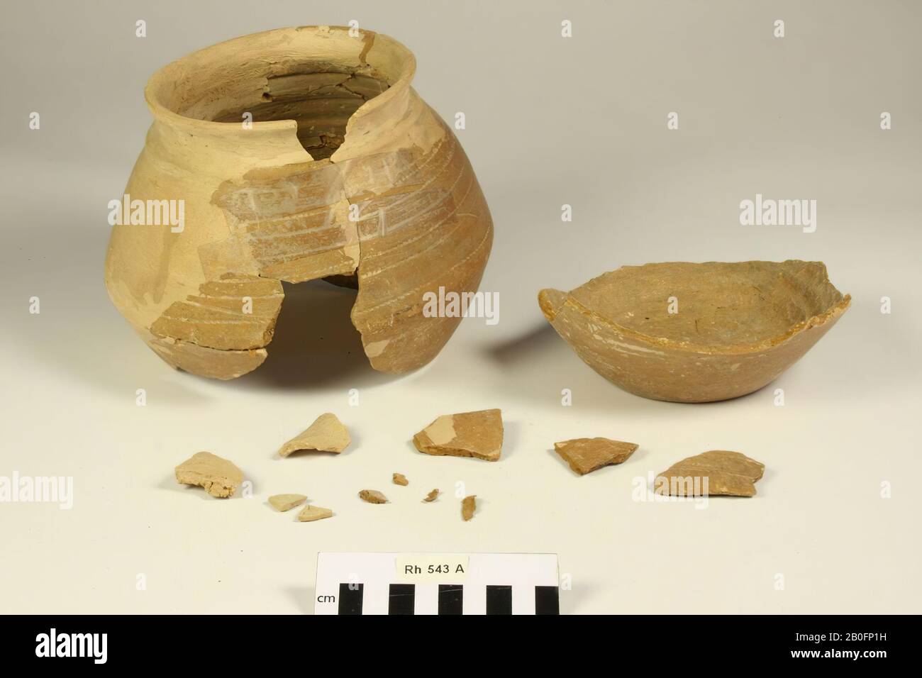 Knikpot of smooth-walled, Frankish earthenware with wheel mark decoration. Old bondings and additions, loose soil, 4 loose fragments and 5 chips, pot is plastered with pieces of tape, kink, pottery (smooth wall) (Frankish), h: 16.3 cm, diam: 22 cm, vmeb, Netherlands, Utrecht, Rhenen, Rhenen, grave 543 Stock Photo