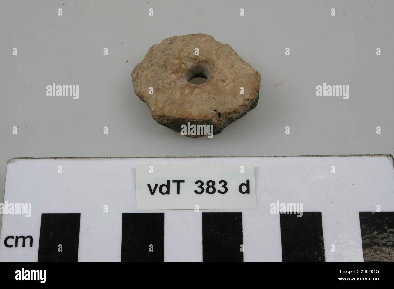 Earthenware disc with perforation in the middle., disk, earthenware, h: 1 cm, diam: 3,5 cm, vme, Netherlands, Friesland, Ferwerderadiel, Lichtaard Stock Photo