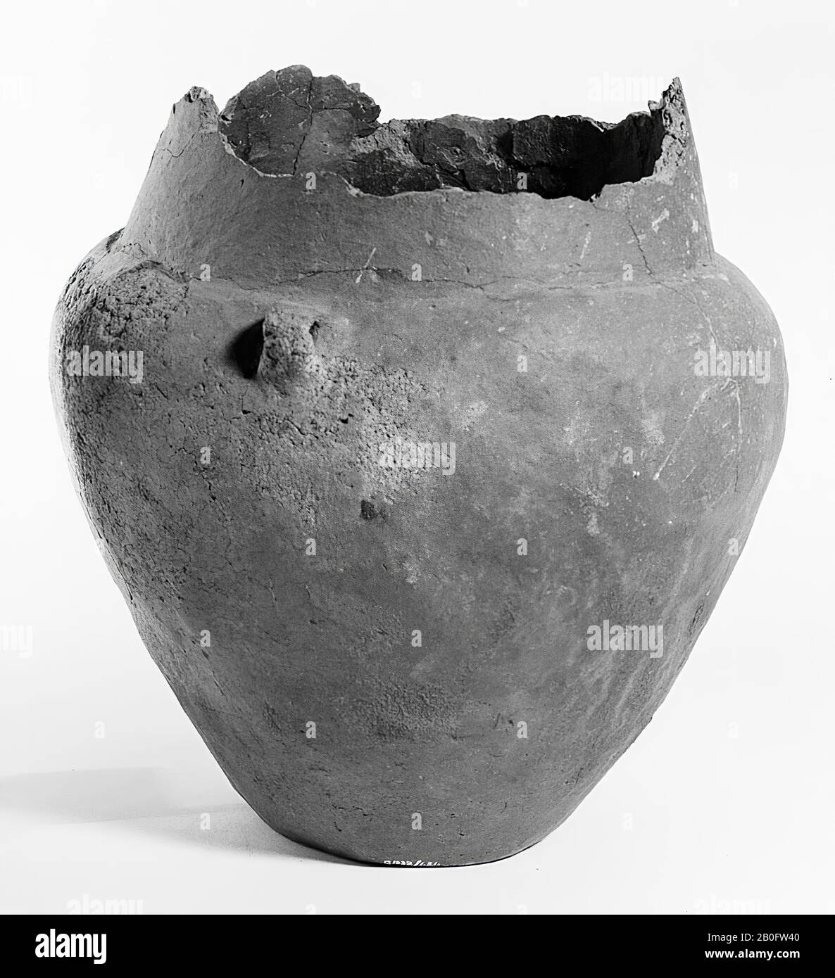 Proto-Saxon urn of earthenware with two ears on the shoulder. Terrine shape. The edge is broken off, various additions, small cracks over the entire object. Contains cremated residues, urn, earthenware, h: 27 cm, diam: 24.5 cm, prehistory -1200 Stock Photo