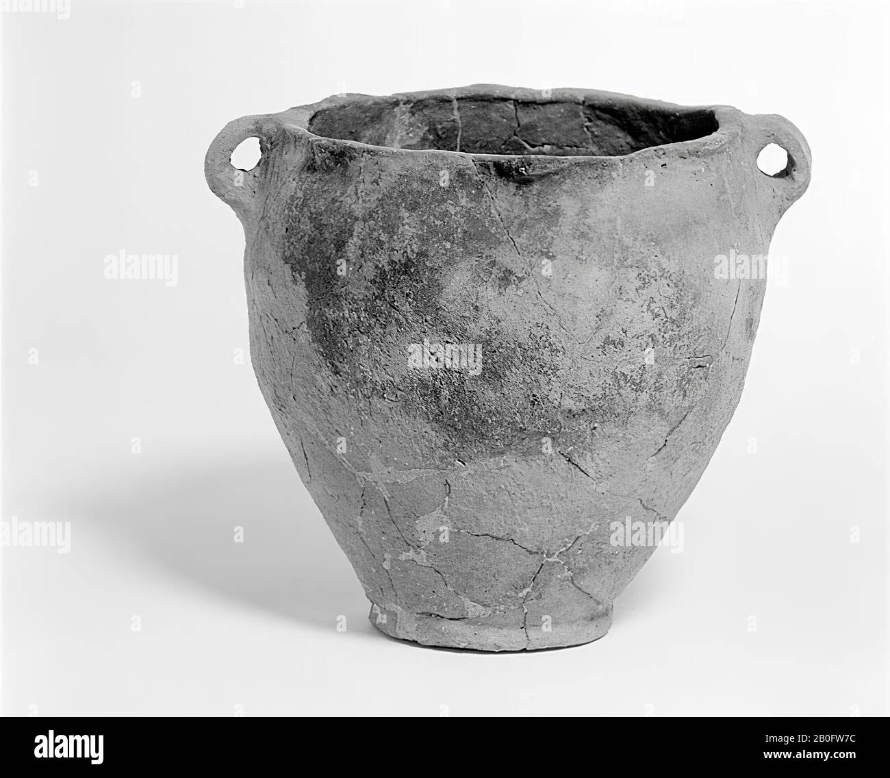 Pot of raw earthenware with flat edges, bent over here and there and two ears. Many old glueing and some small additions, fragment of the foot is missing., Pot, earthenware, h: 17.3 cm, br (incl. Ears): 19.5 cm, prehistory -1200 Stock Photo