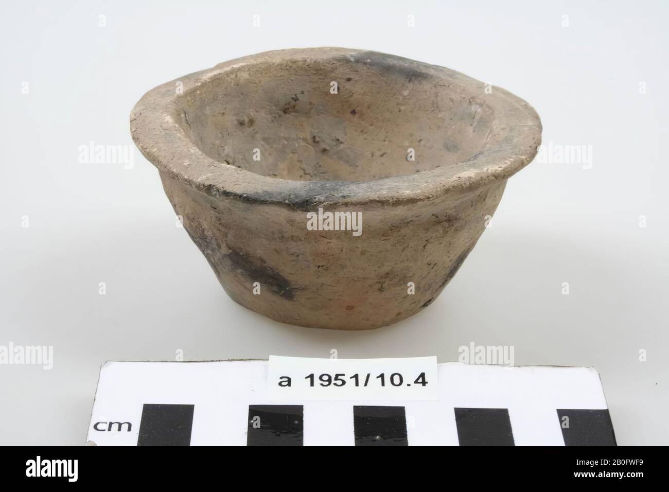 Inverted-frustoconical cup of light gray, hand shaped pottery with black spots, flat edge., cup, earthenware (hand shaped), h: 4,6 cm, diam: 9,2 cm, roman, Netherlands, Friesland , Ferwerderadiel, Janum Stock Photo