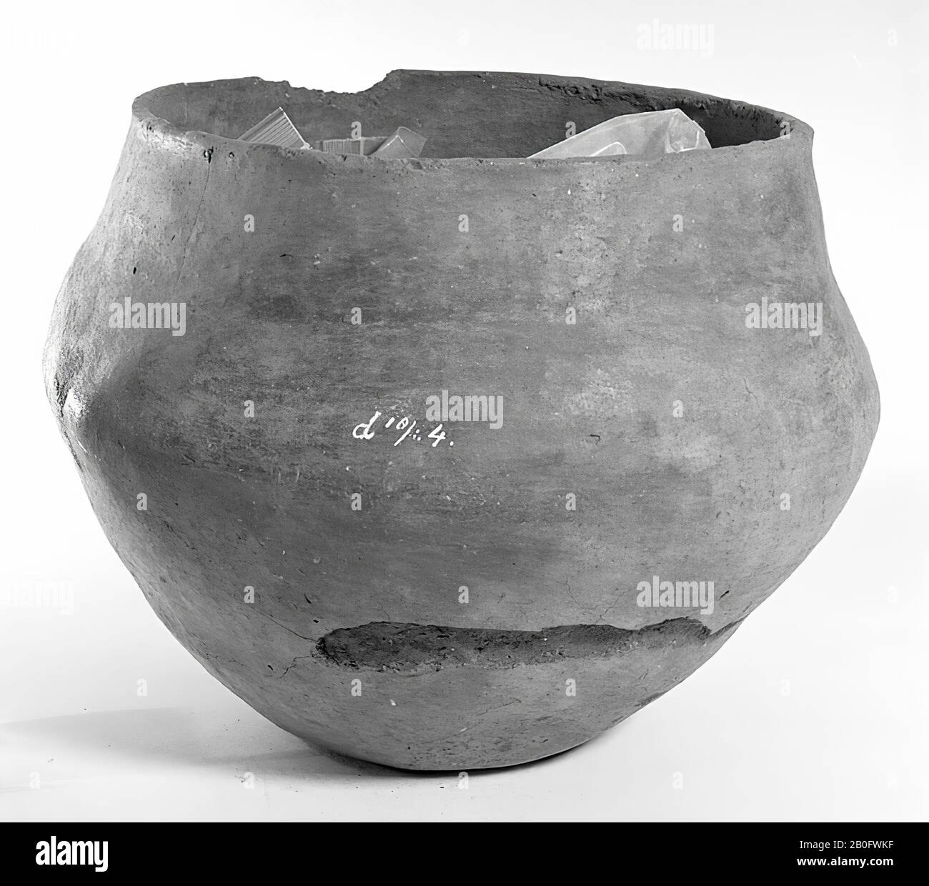 Urn of earthenware. The edge is damaged, cracks in the edge, especially horizontal surface cracks, surface damage. Contains cremated residues, urn, earthenware, h: 22 cm, diam: 30 cm, prehistory -1200 Stock Photo