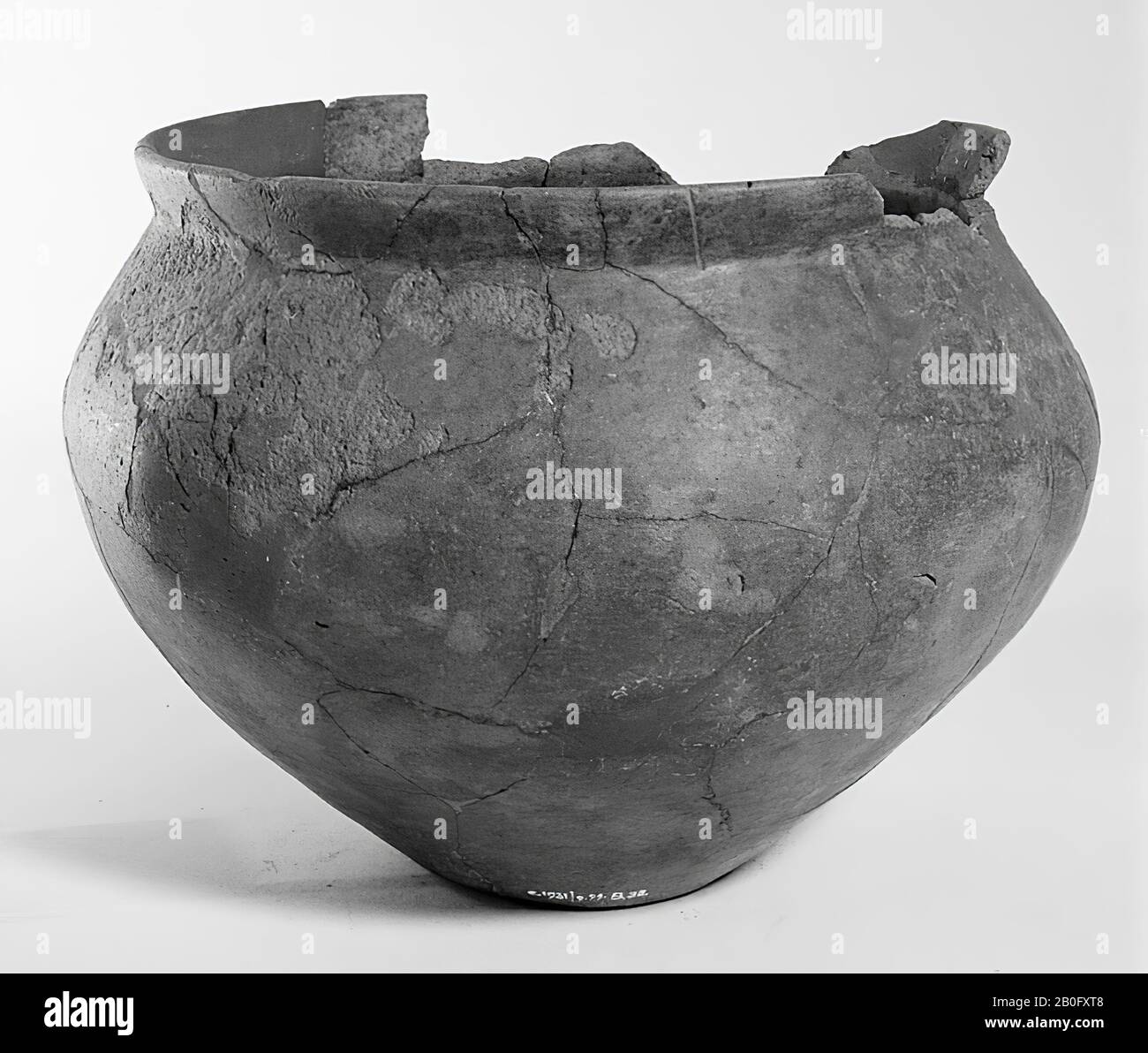 Gallo-Germanic urn of earthenware without decoration. Edge defect. Unstable old bonding and additions, cracks, surface damage, 2 separate fragments. Contains cremated residues, urn, earthenware, h: 18.5 cm, diam: 25 cm, prehistory -1200 Stock Photo