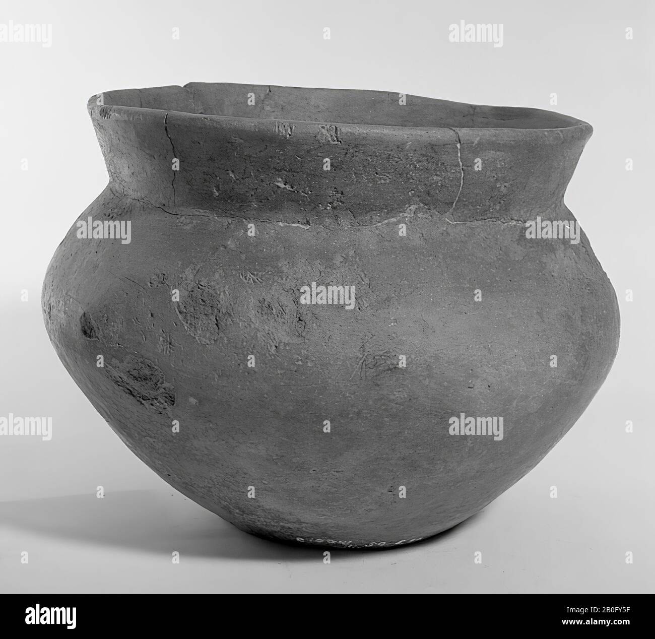Urn of earthenware with sharp shoulder buckling and gradually tapering upwards. Oblique fairly wide edge. Glueing and additions in the rim, cracking in the wall, urn, pottery, h: 16 cm, diam: 21 cm, prehistory -800 Stock Photo